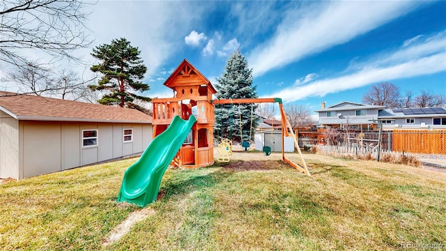 view of play area featuring an outbuilding, a storage shed, a lawn, and fence