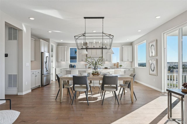 dining space featuring a notable chandelier and dark hardwood / wood-style flooring