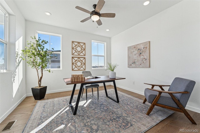 home office featuring hardwood / wood-style floors, ceiling fan, and a wealth of natural light