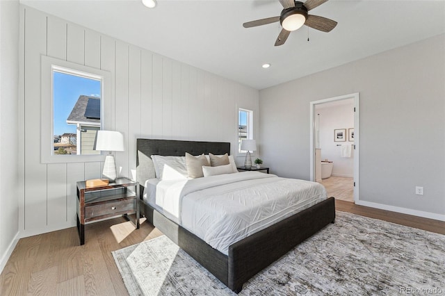 bedroom featuring hardwood / wood-style flooring, ceiling fan, and connected bathroom