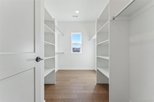 walk in closet with light hardwood / wood-style flooring