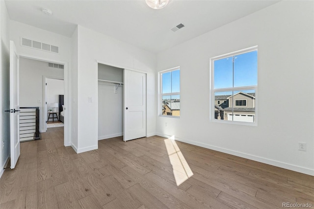 unfurnished bedroom with a closet and light wood-type flooring