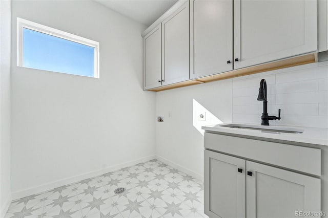 laundry area with cabinets and sink