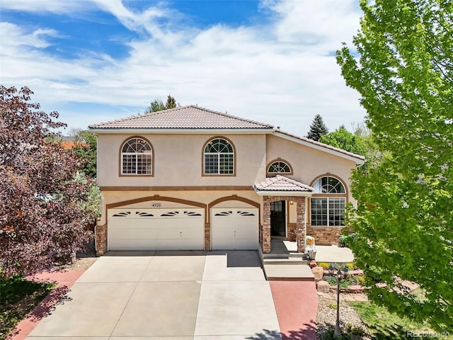 4520 Maroon Cir, Broomfield, CO 80023 - mediterranean / spanish-style house featuring concrete driveway, a garage, stucco siding, and stone siding