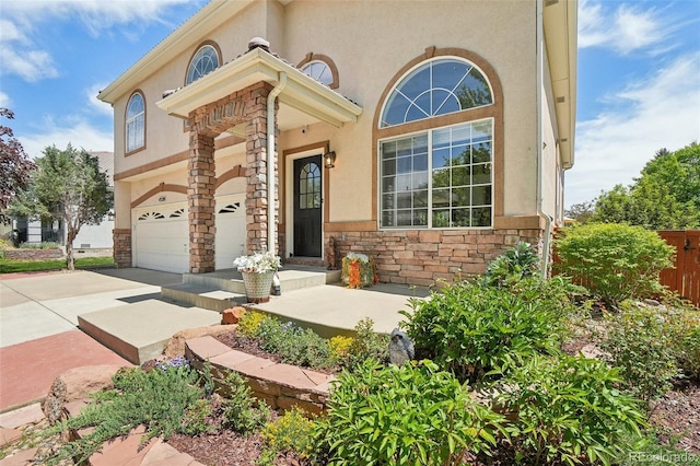 4520 Maroon Cir, Broomfield, CO 80023 - view of front of home featuring stone siding, concrete driveway, stucco siding, an attached garage, and fence