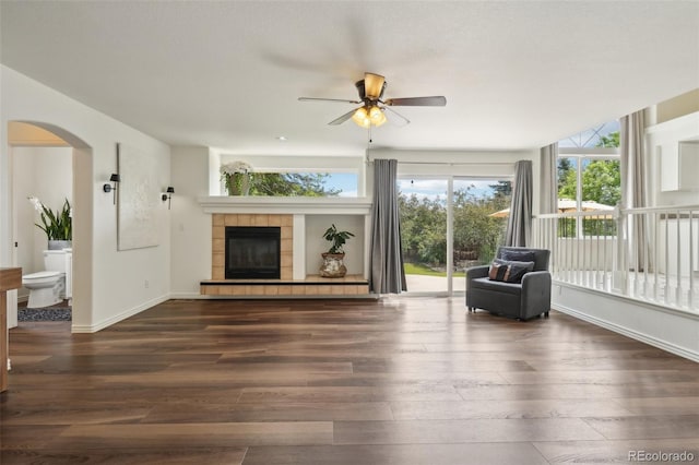 4520 Maroon Cir, Broomfield, CO 80023 - living room with wood-type flooring, ceiling fan, arched walkways, and a fireplace