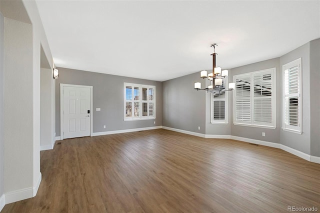 interior space featuring a notable chandelier, baseboards, and wood finished floors