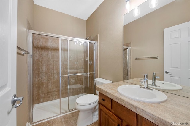 bathroom featuring a shower stall, toilet, and vanity