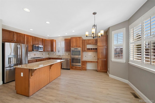 kitchen featuring a sink, visible vents, baseboards, appliances with stainless steel finishes, and backsplash