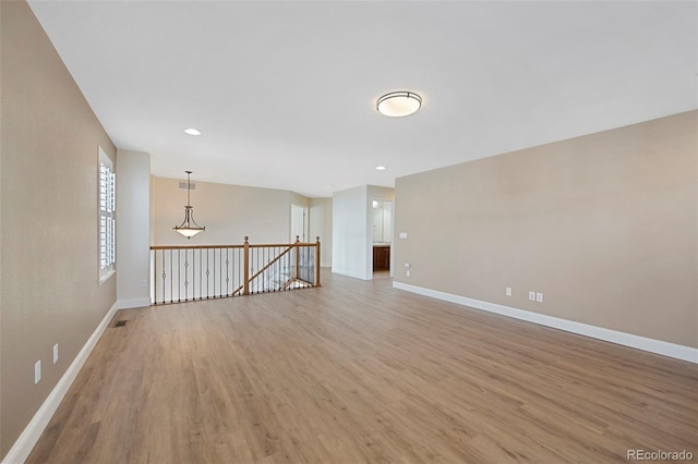 unfurnished room with light wood-style floors, visible vents, baseboards, and recessed lighting