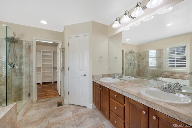 full bath featuring a stall shower, a sink, and visible vents