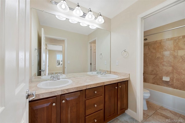 full bathroom featuring double vanity, tile patterned flooring, a sink, and toilet