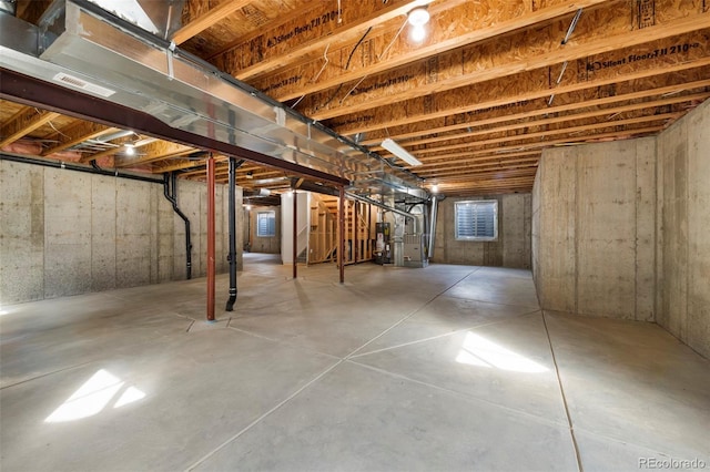 unfinished basement featuring visible vents and heating unit