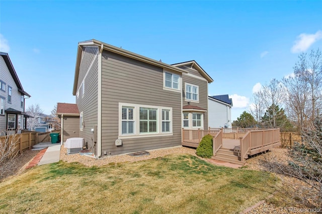 back of house with a fenced backyard, a yard, and a wooden deck