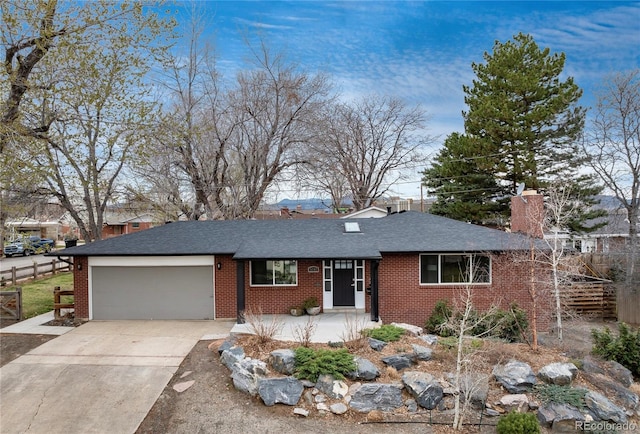 5743 Field St, Arvada, CO 80002 - ranch-style home featuring a garage, concrete driveway, brick siding, and a chimney