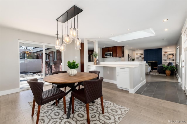 5743 Field St, Arvada, CO 80002 - dining room featuring wood finished floors, a skylight, recessed lighting, and baseboards