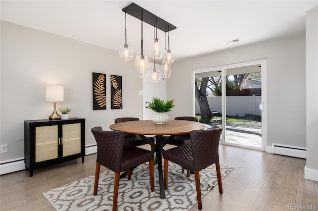 5743 Field St, Arvada, CO 80002 - dining space featuring a baseboard heating unit, light wood-style flooring, and a chandelier