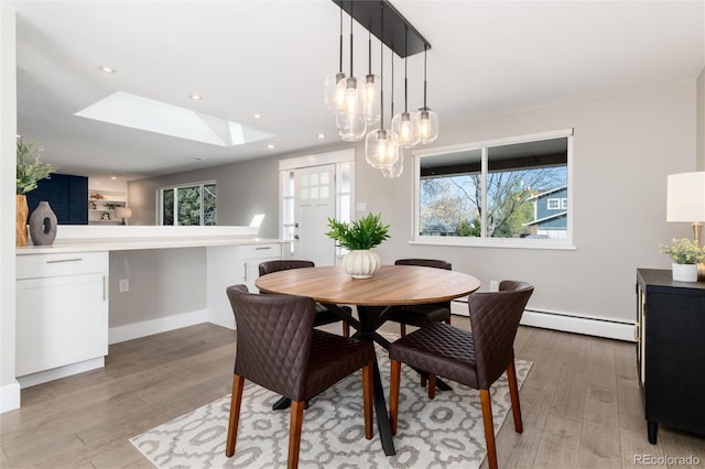 5743 Field St, Arvada, CO 80002 - dining area featuring a baseboard heating unit, a skylight, light wood-type flooring, a chandelier, and recessed lighting
