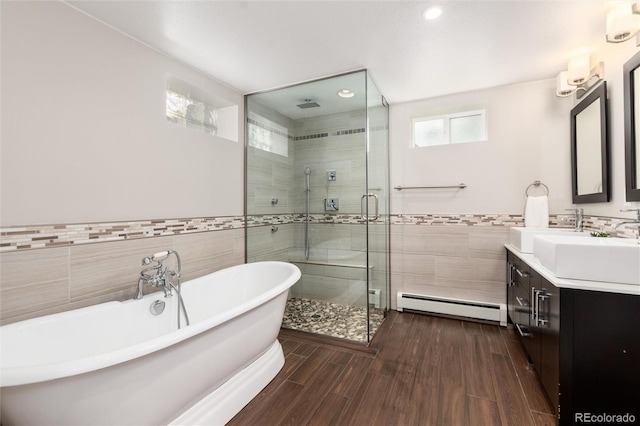 5743 Field St, Arvada, CO 80002 - bathroom featuring tile walls, a baseboard radiator, vanity, a stall shower, and a freestanding tub