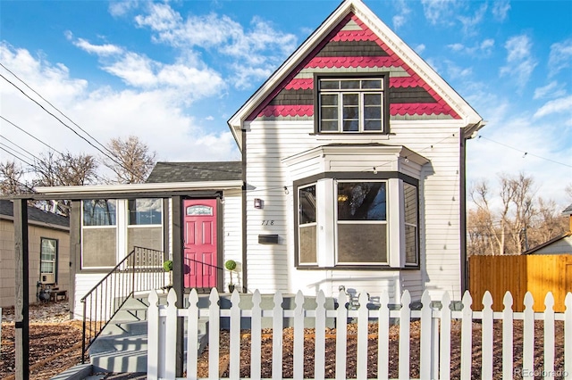 victorian house featuring a fenced front yard