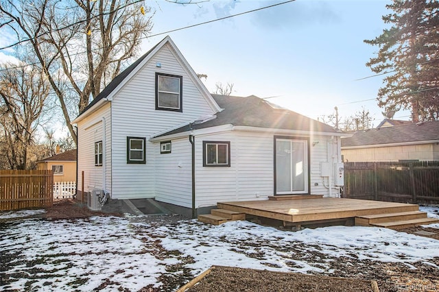 snow covered property with fence, cooling unit, and a wooden deck