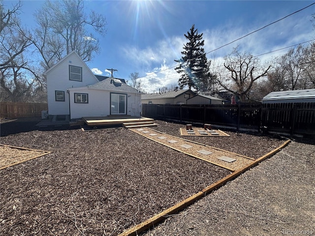 back of property with a fenced backyard and a wooden deck