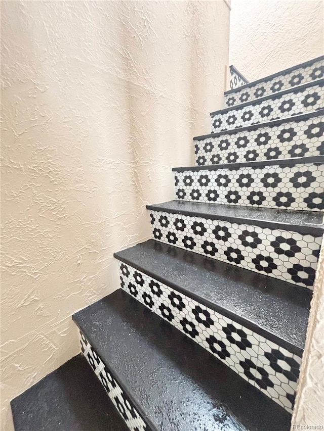 stairway featuring a textured wall