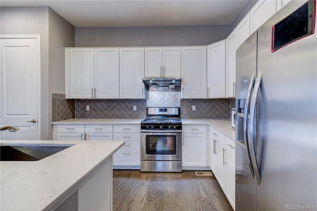 kitchen featuring white cabinets, dark wood-style flooring, extractor fan, stainless steel appliances, and a sink