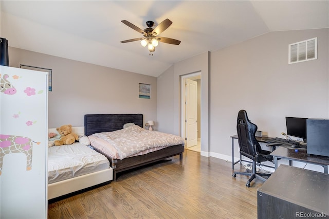 bedroom featuring baseboards, visible vents, a ceiling fan, wood finished floors, and vaulted ceiling