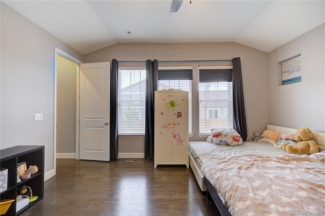 bedroom featuring multiple windows, vaulted ceiling, and dark wood finished floors