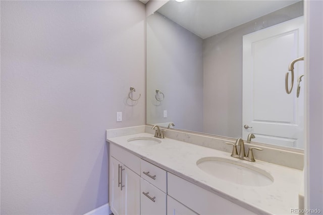 bathroom featuring a sink and double vanity