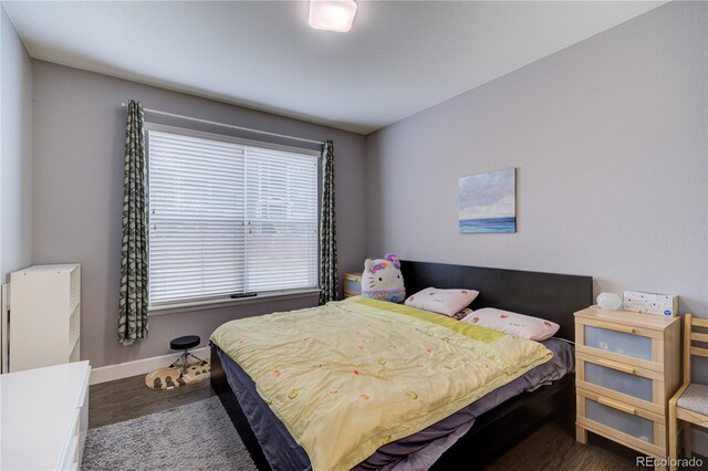 bedroom with wood finished floors and baseboards