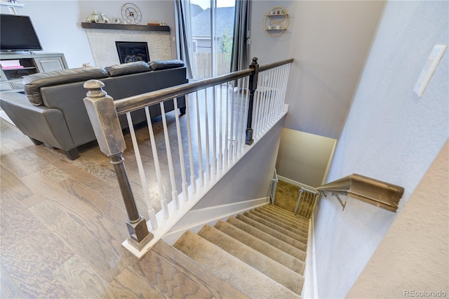 stairs featuring a glass covered fireplace