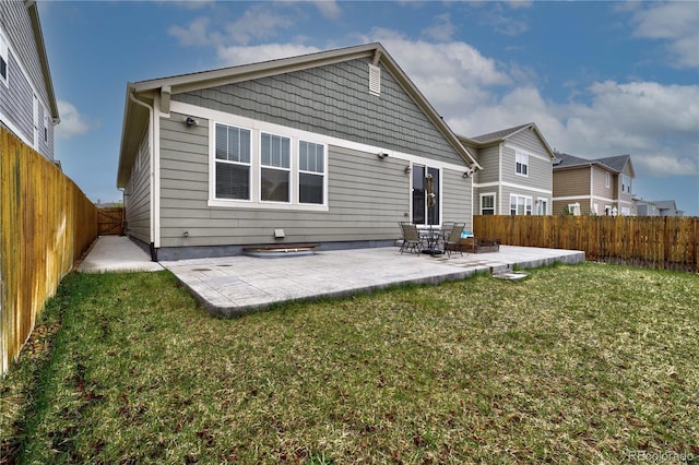 rear view of property featuring a lawn, a patio area, and a fenced backyard