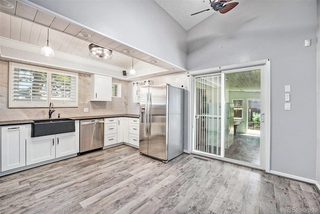 7773 Brentwood Ct, Arvada, CO 80005 - kitchen featuring appliances with stainless steel finishes, a sink, dark countertops, light wood-type flooring, and ceiling fan