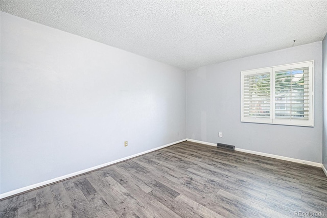 7773 Brentwood Ct, Arvada, CO 80005 - spare room with wood finished floors, a textured ceiling, and baseboards