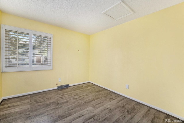 7773 Brentwood Ct, Arvada, CO 80005 - empty room featuring attic access, wood finished floors, baseboards, and a textured ceiling