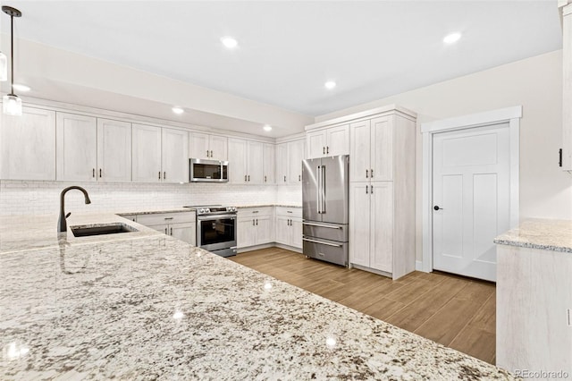 kitchen featuring decorative light fixtures, white cabinetry, stainless steel appliances, sink, and backsplash