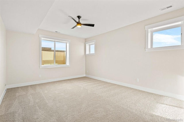 empty room with ceiling fan, carpet, and a wealth of natural light