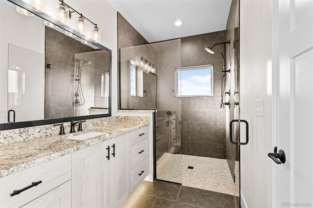 bathroom featuring an enclosed shower, vanity, and tile patterned flooring