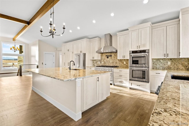 kitchen with premium appliances, decorative light fixtures, lofted ceiling with beams, a notable chandelier, and wall chimney range hood