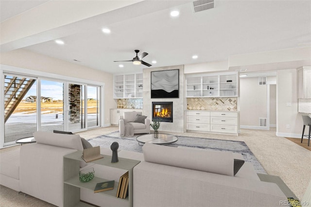 living room featuring ceiling fan and a premium fireplace