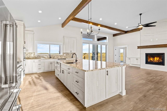 17155 Twinkling Star Ln, Colorado Springs, CO 80908 - kitchen with stainless steel appliances, a sink, tasteful backsplash, beamed ceiling, and a large island