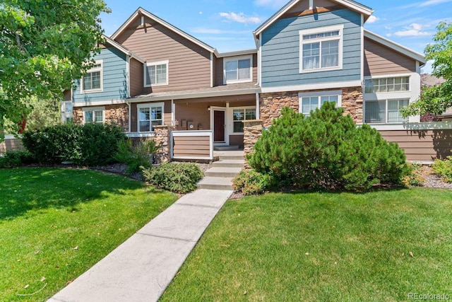 13231 Holly St Unit B, Thornton, CO 80241 - view of front of house with stone siding, covered porch, and a front lawn
