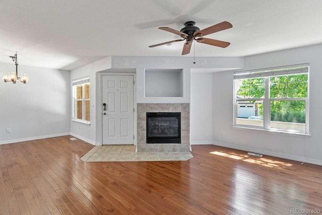 13231 Holly St Unit B, Thornton, CO 80241 - unfurnished living room featuring a chandelier, a fireplace, hardwood / wood-style floors, and ceiling fan