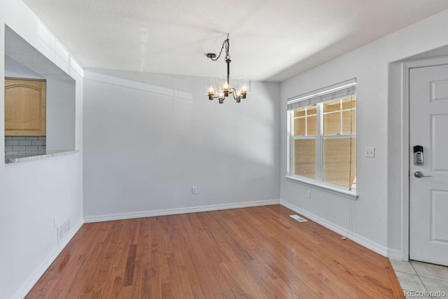 13231 Holly St Unit B, Thornton, CO 80241 - unfurnished dining area with light wood finished floors and a chandelier