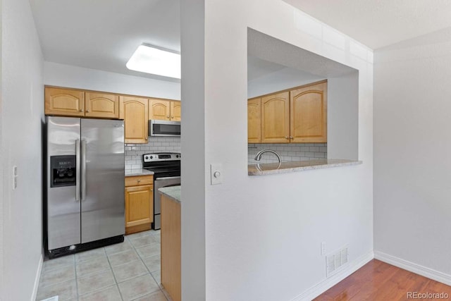 13231 Holly St Unit B, Thornton, CO 80241 - kitchen with appliances with stainless steel finishes, tasteful backsplash, and light countertops