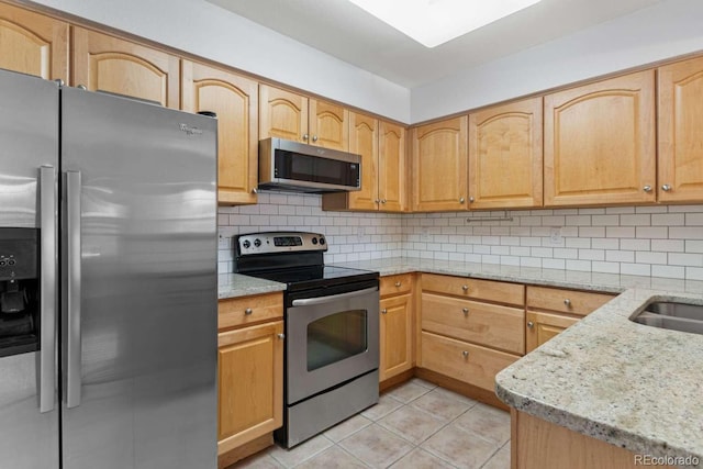 13231 Holly St Unit B, Thornton, CO 80241 - kitchen featuring stainless steel appliances, light tile patterned floors, light stone countertops, and tasteful backsplash