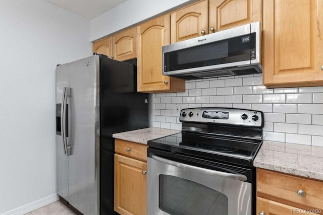 13231 Holly St Unit B, Thornton, CO 80241 - kitchen featuring stainless steel appliances, decorative backsplash, light brown cabinets, and light stone countertops