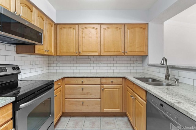 13231 Holly St Unit B, Thornton, CO 80241 - kitchen featuring appliances with stainless steel finishes, light stone countertops, tasteful backsplash, and light tile patterned flooring